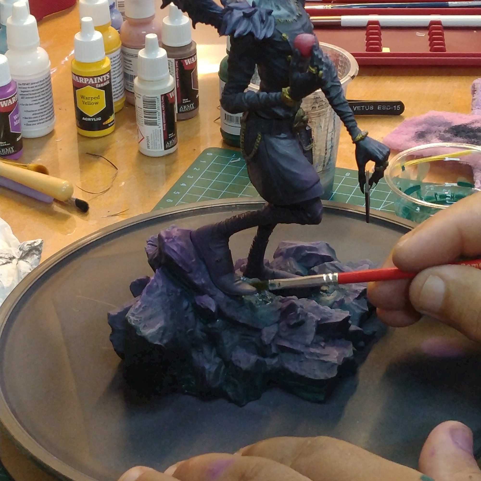 Hand painting a detailed resin fantasy figure with acrylic paints.