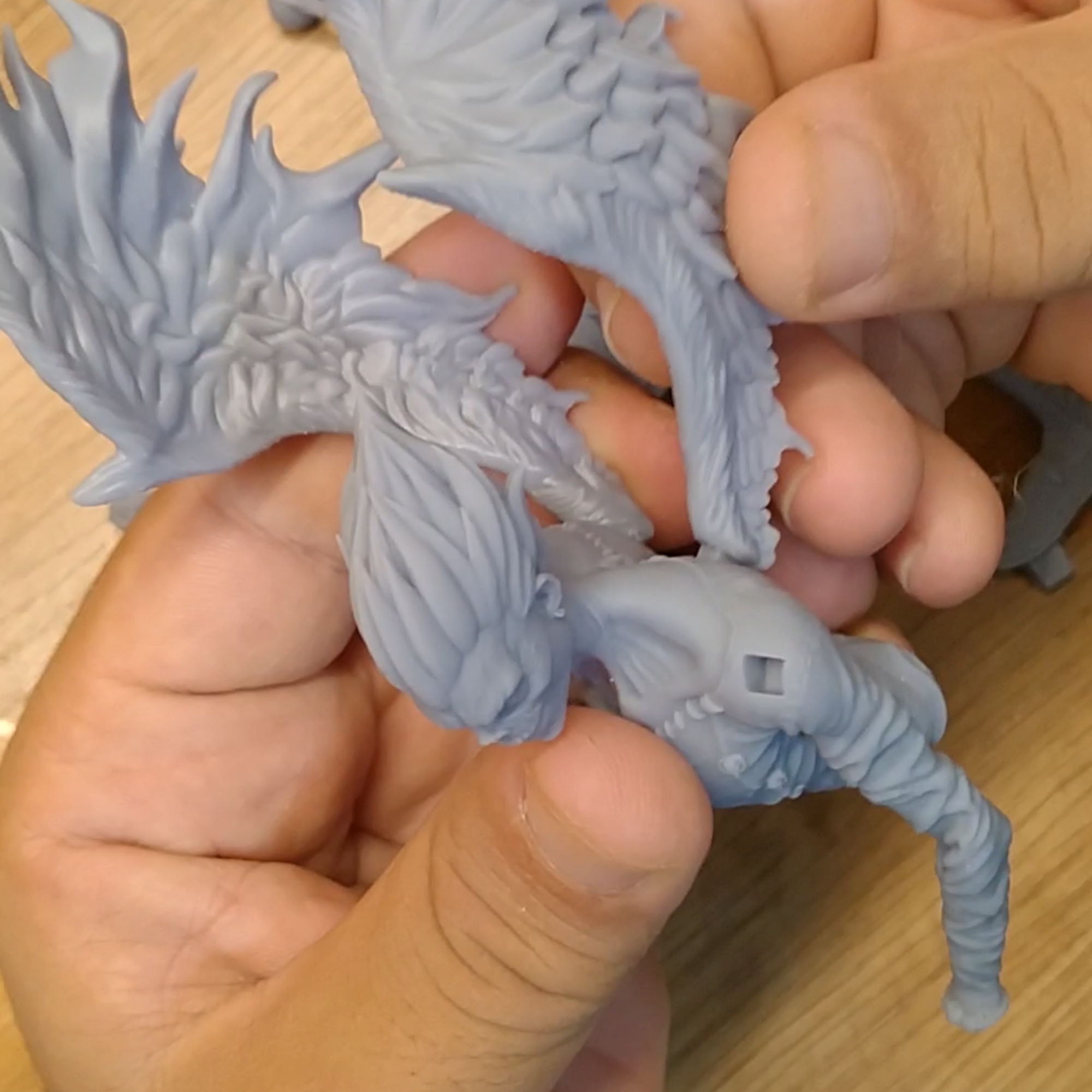 Test-fitting detailed resin 3D printed fantasy figure parts before assembly.