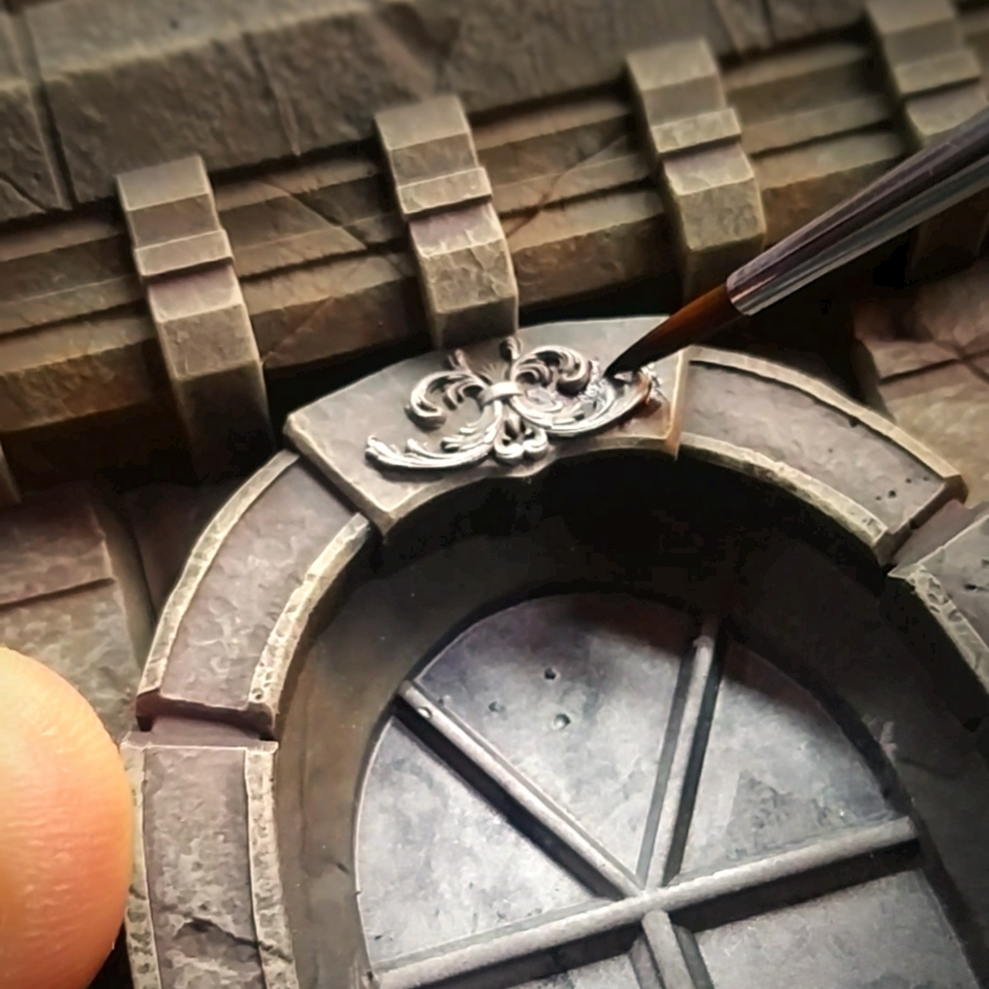 Applying final painted details to a resin 3D printed miniature base.